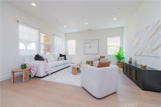 living area featuring recessed lighting, plenty of natural light, and light wood-type flooring