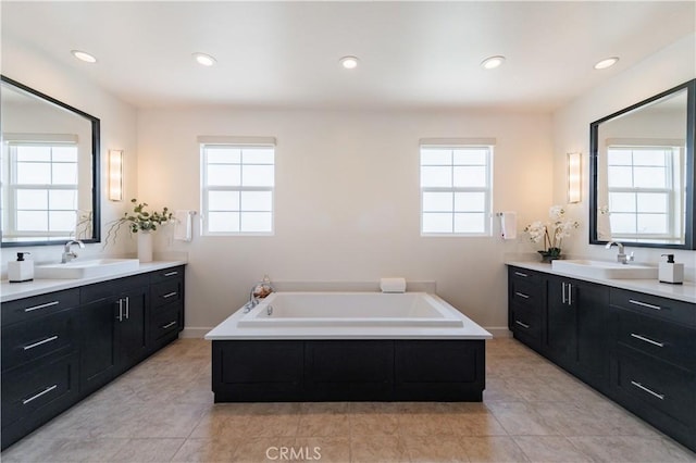 bathroom with a sink, two vanities, and a healthy amount of sunlight