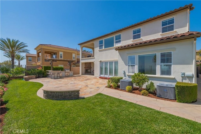 back of property with a patio, cooling unit, stucco siding, a balcony, and a yard
