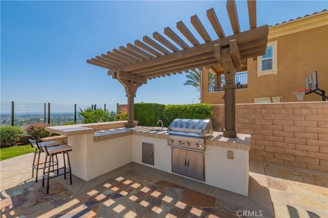view of patio featuring fence, area for grilling, outdoor wet bar, a pergola, and an outdoor kitchen