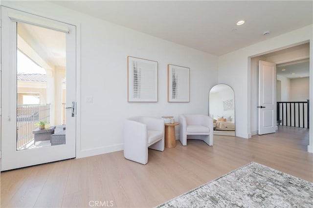 living area with recessed lighting, baseboards, and wood finished floors