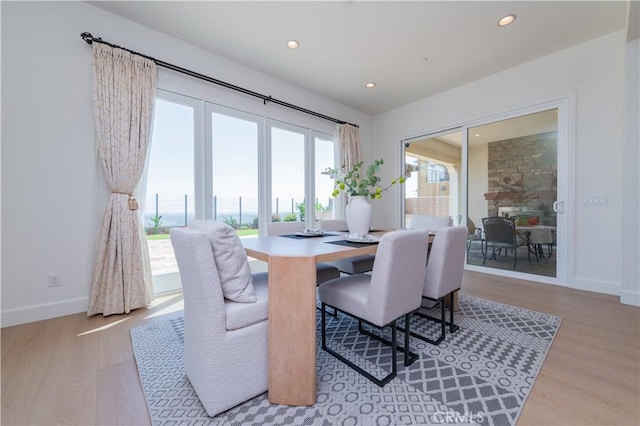dining space featuring wood finished floors, baseboards, and recessed lighting