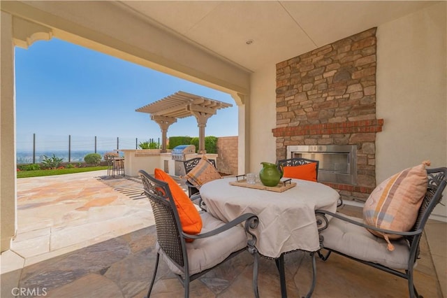view of patio / terrace with area for grilling, an outdoor stone fireplace, and outdoor dining space