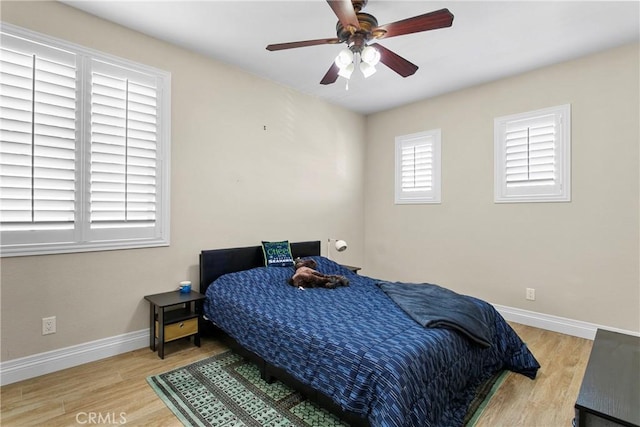 bedroom with baseboards, a ceiling fan, and wood finished floors