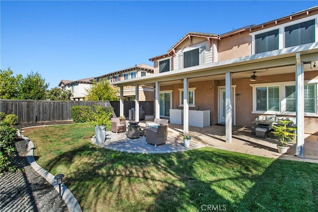 rear view of property featuring a patio, stucco siding, a fenced backyard, a yard, and an outdoor living space