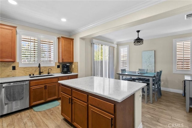 kitchen featuring stainless steel dishwasher, a sink, decorative backsplash, a kitchen island, and light wood-type flooring