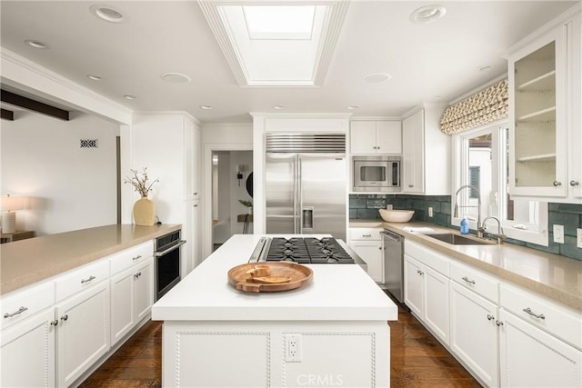 32491 Seven Seas Dr, Dana Point, CA 92629 - kitchen with built in appliances, glass insert cabinets, a sink, white cabinetry, and backsplash