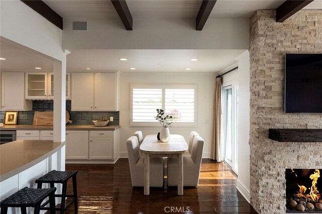 32491 Seven Seas Dr, Dana Point, CA 92629 - dining room featuring a stone fireplace, beamed ceiling, plenty of natural light, dark wood finished floors, and recessed lighting