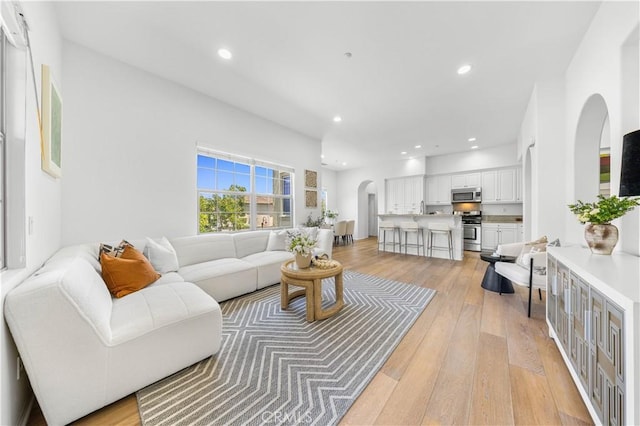 71 Nature, Irvine, CA 92620 - living area with arched walkways, light wood-style floors, and recessed lighting