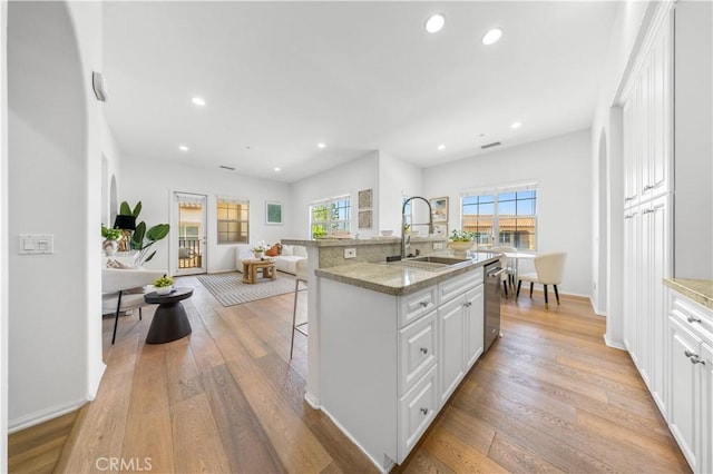 71 Nature, Irvine, CA 92620 - kitchen with a sink, dishwasher, a breakfast bar, light wood-style floors, and recessed lighting