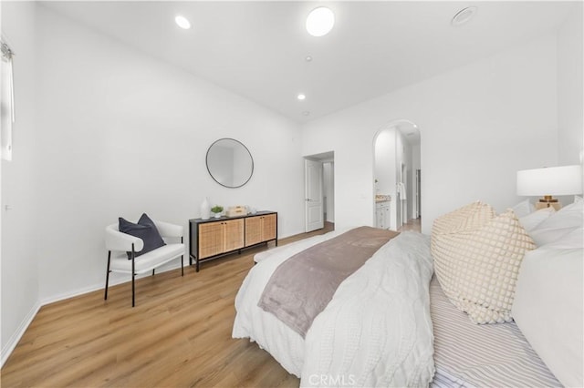 71 Nature, Irvine, CA 92620 - bedroom with arched walkways, light wood-style flooring, recessed lighting, baseboards, and connected bathroom