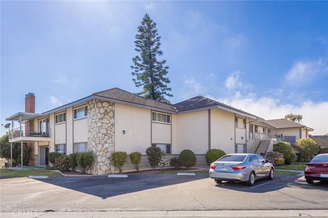 23026 Nadine Cir Unit B, Torrance, CA 90505 - exterior space with uncovered parking, a chimney, stucco siding, and stairs