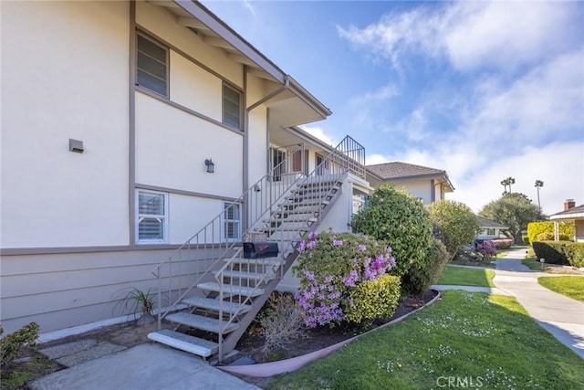 23026 Nadine Cir Unit B, Torrance, CA 90505 - view of side of home featuring a lawn, stairway, and stucco siding