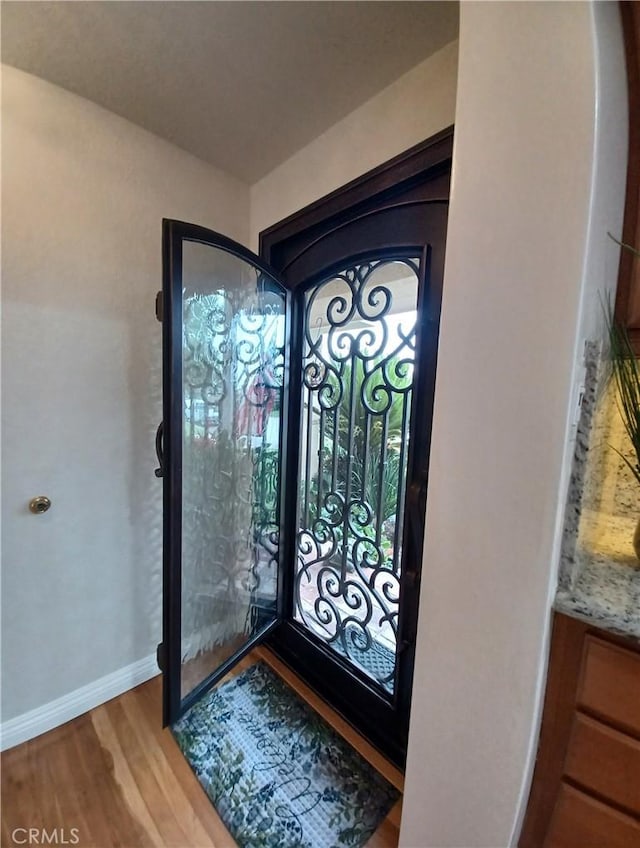 entryway featuring baseboards and wood finished floors