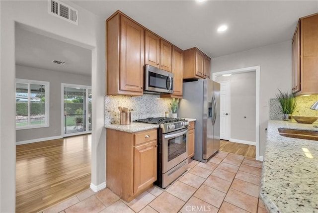 kitchen with baseboards, visible vents, appliances with stainless steel finishes, and a sink