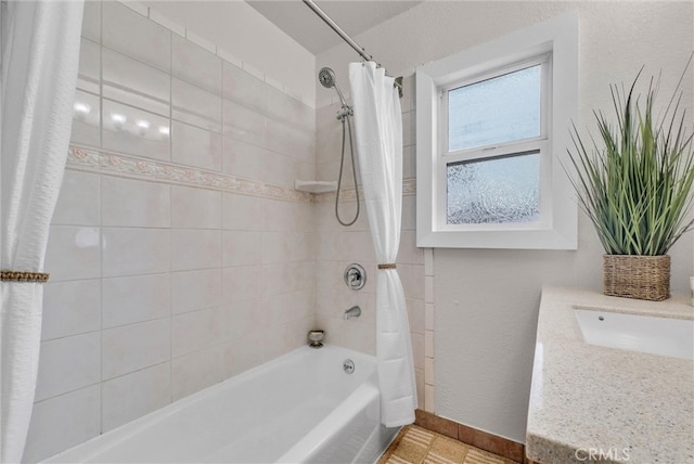 bathroom featuring a sink, shower / tub combo with curtain, and baseboards