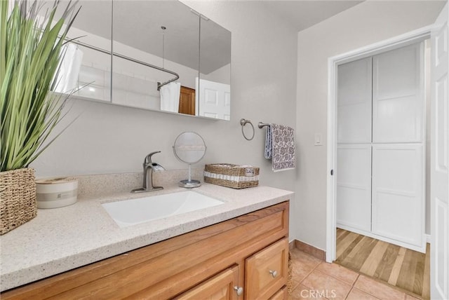 bathroom with baseboards, tile patterned flooring, and vanity