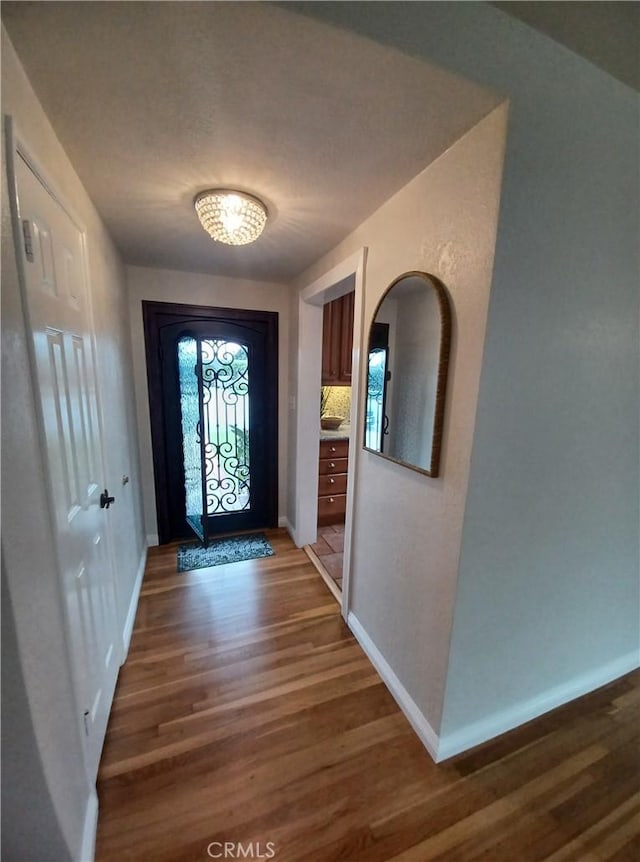 entryway with wood finished floors and baseboards