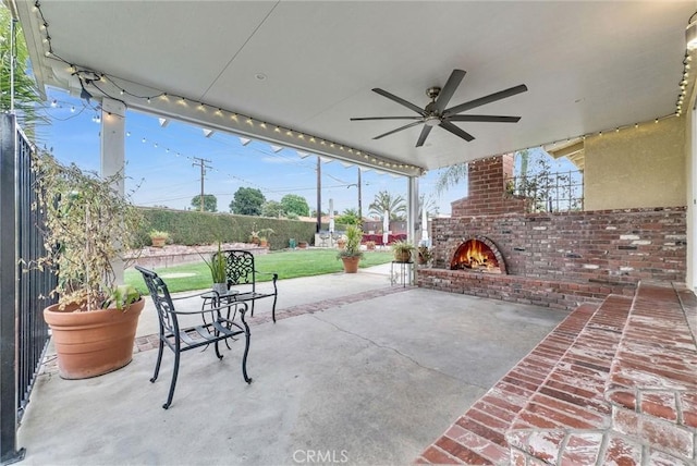 view of patio / terrace with a fenced backyard, an outdoor brick fireplace, and a ceiling fan