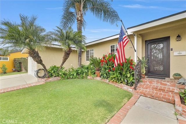view of front of property with a front lawn, concrete driveway, and stucco siding
