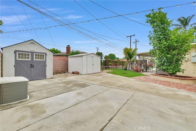 view of patio / terrace with an outbuilding, a shed, and a fenced backyard