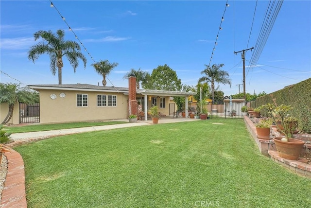 exterior space featuring a patio, stucco siding, a fenced backyard, a chimney, and a lawn