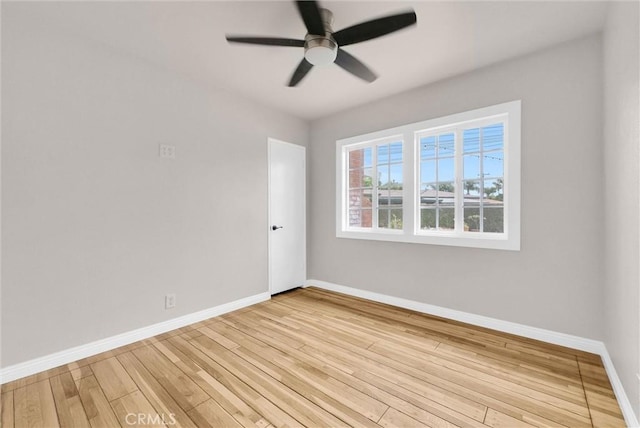 empty room featuring light wood-style floors, baseboards, and a ceiling fan