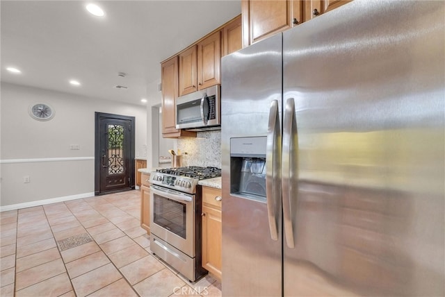 kitchen with light tile patterned floors, stainless steel appliances, backsplash, light stone counters, and recessed lighting