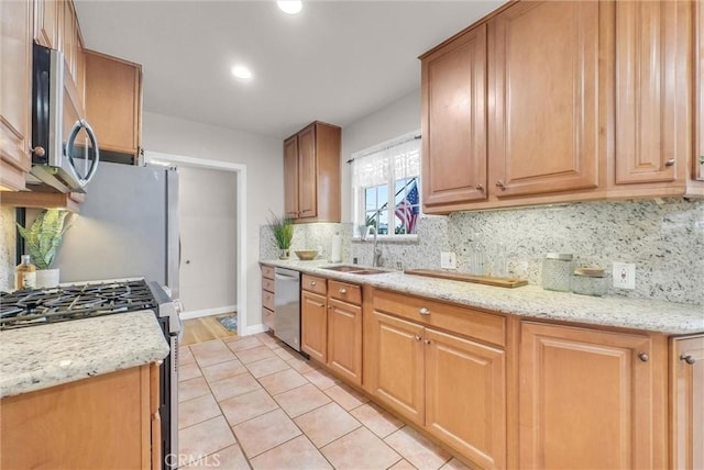 kitchen with a sink, baseboards, appliances with stainless steel finishes, decorative backsplash, and recessed lighting
