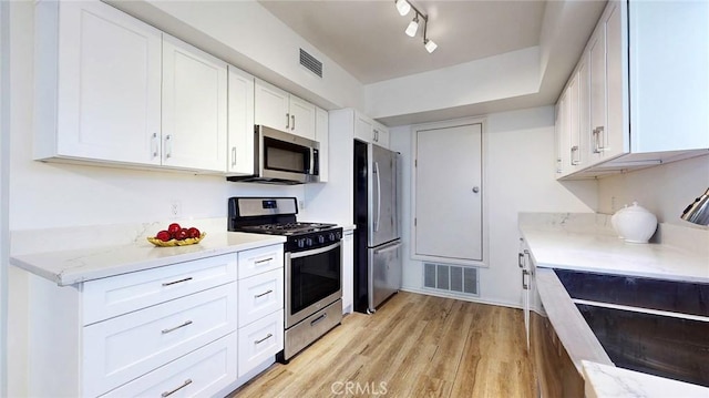 11725 Lemay St Unit 1, North Hollywood, CA 91606 - kitchen with white cabinetry, stainless steel appliances, light wood-type flooring, and visible vents