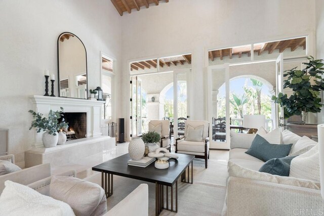 3247 Cerros Redondos, Rancho Santa Fe, CA 92067 - living area featuring wood ceiling, beam ceiling, high vaulted ceiling, and a lit fireplace