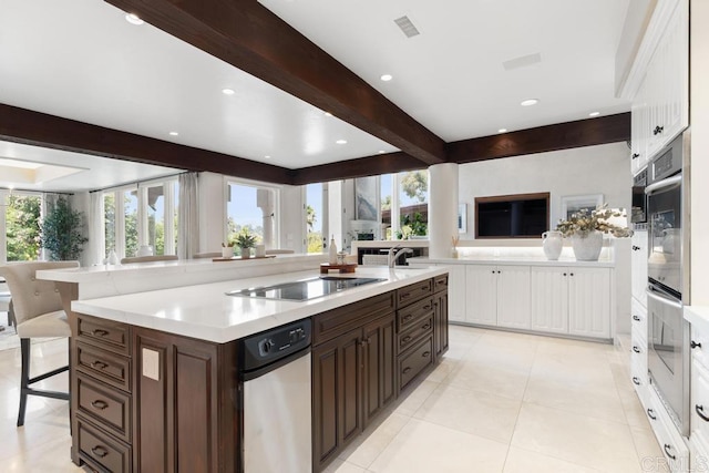 3247 Cerros Redondos, Rancho Santa Fe, CA 92067 - kitchen with black electric stovetop, beam ceiling, double oven, dark brown cabinetry, and white cabinets