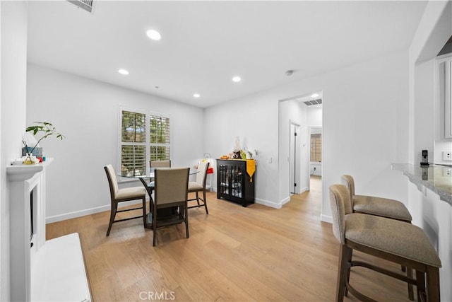 dining area with light wood-type flooring, recessed lighting, and baseboards