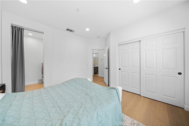 bedroom with light wood-style floors, recessed lighting, and a closet