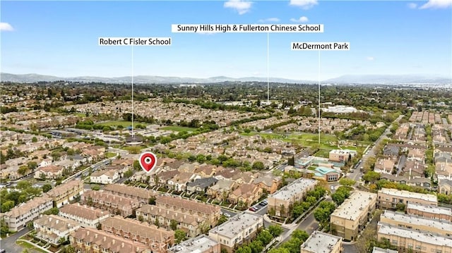 aerial view of property's location featuring a mountainous background and nearby suburban area