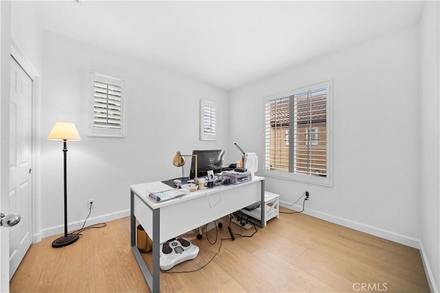 office space with baseboards and light wood finished floors