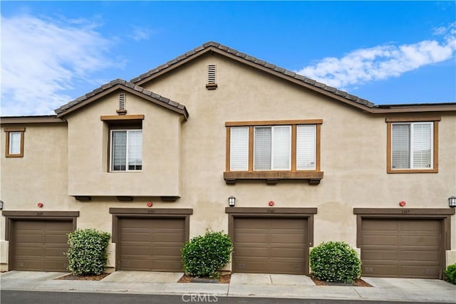 view of property featuring stucco siding and a garage