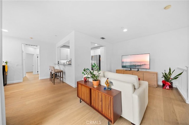 living area with light wood-style floors, recessed lighting, and baseboards