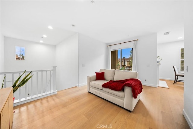 living area with light wood-style floors, recessed lighting, and baseboards