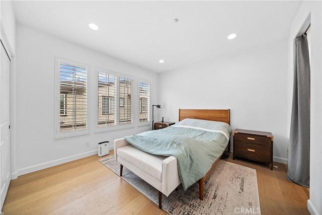 bedroom with wood finished floors, baseboards, and recessed lighting
