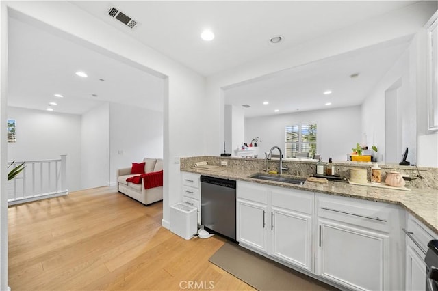 kitchen with dishwasher, a sink, light wood-type flooring, white cabinetry, and light stone countertops