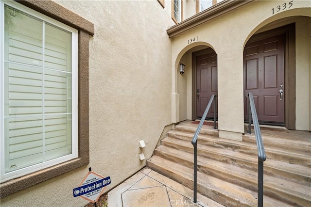 doorway to property featuring stucco siding