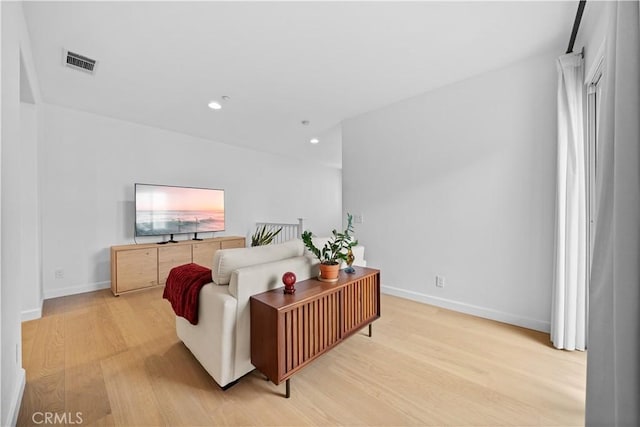 living area with light wood-style flooring, recessed lighting, and baseboards