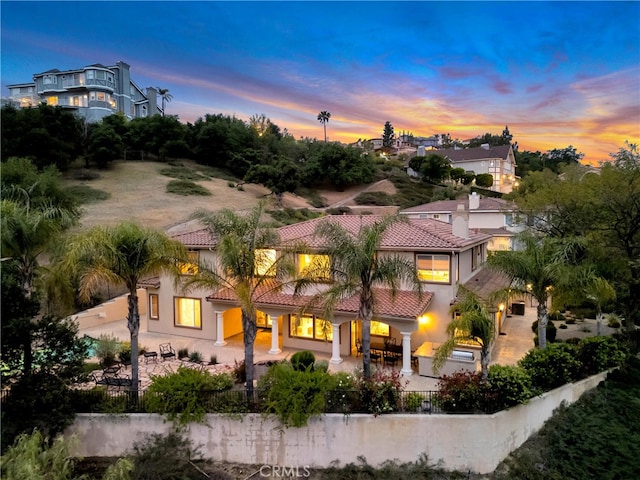 9420 Oak Leaf Dr, Chatsworth, CA 91311 - back of house at dusk with a patio, a tiled roof, stucco siding, and fence private yard