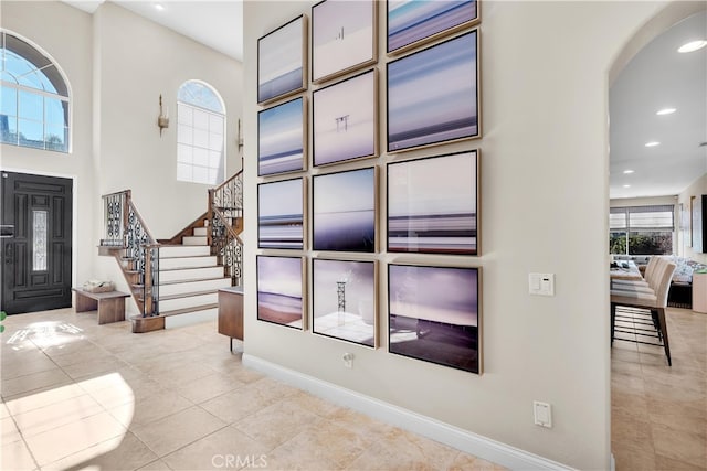 9420 Oak Leaf Dr, Chatsworth, CA 91311 - entryway with recessed lighting, stairway, arched walkways, light tile patterned floors, and baseboards