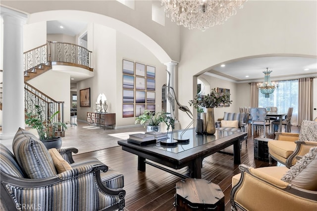 9420 Oak Leaf Dr, Chatsworth, CA 91311 - living room featuring decorative columns, stairway, arched walkways, a high ceiling, and a notable chandelier