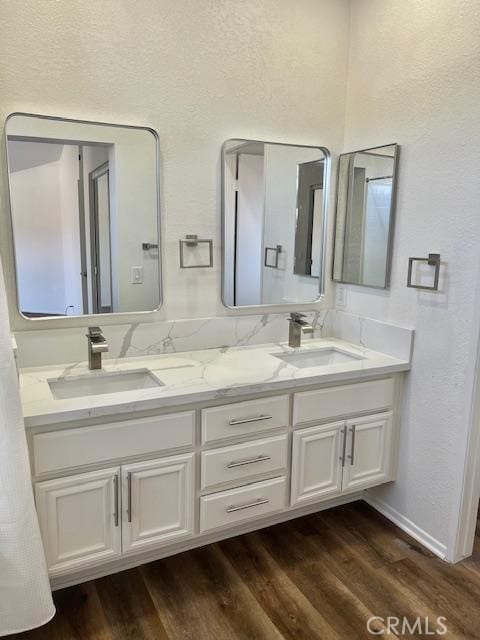 7215 Goldboro Ln, Riverside, CA 92506 - bathroom featuring double vanity, wood finished floors, and a textured wall