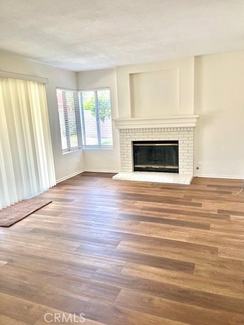 7215 Goldboro Ln, Riverside, CA 92506 - unfurnished living room featuring a fireplace, wood finished floors, and a textured ceiling