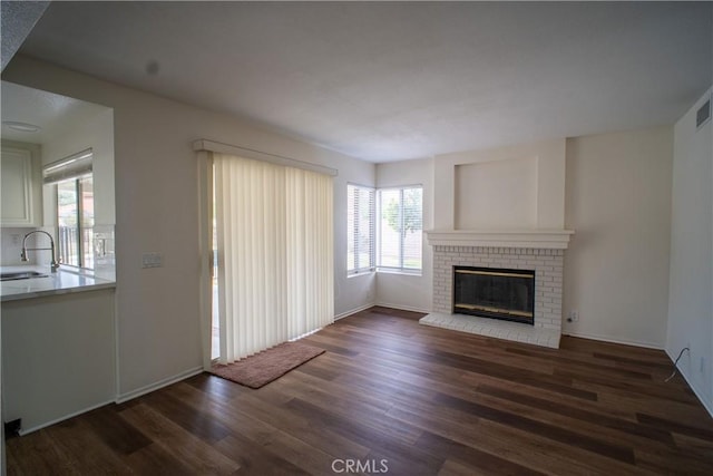 7215 Goldboro Ln, Riverside, CA 92506 - unfurnished living room with dark wood-style floors and a brick fireplace