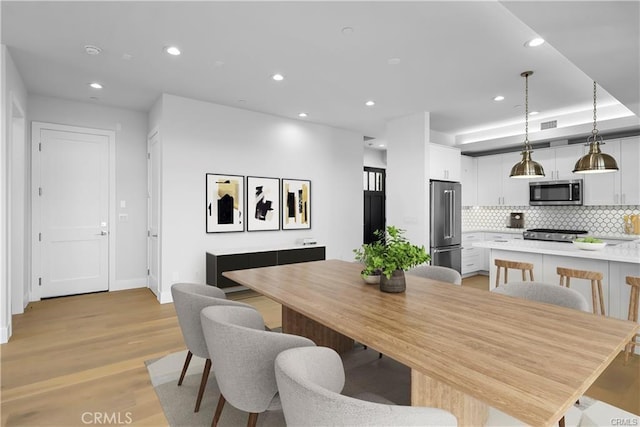 dining area with light wood finished floors, baseboards, visible vents, and recessed lighting